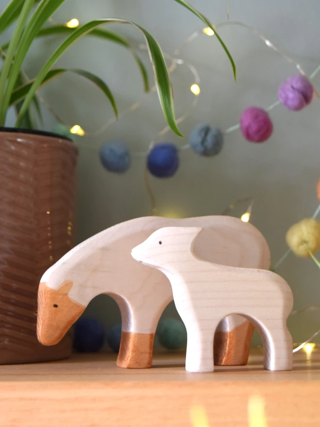 wooden toy white sheep and lamb on shelf 