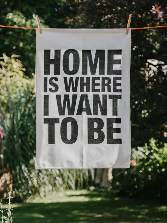 London Drying Home Is Where I Want To Be Tea Towel seen outside,