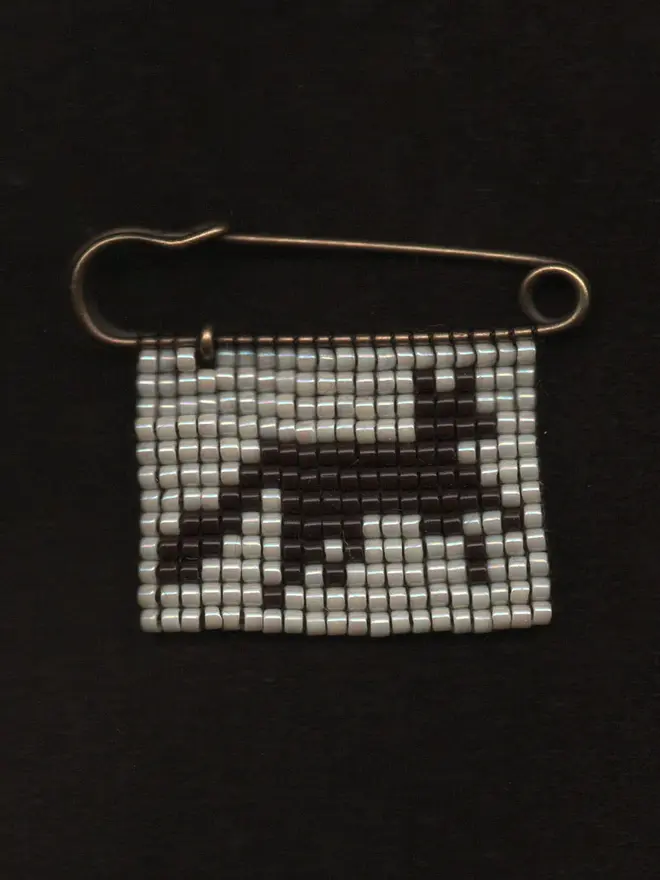 'creature XV' tiled beaded fox pin. a beaded pin badge with a brown fox on a pearl background.