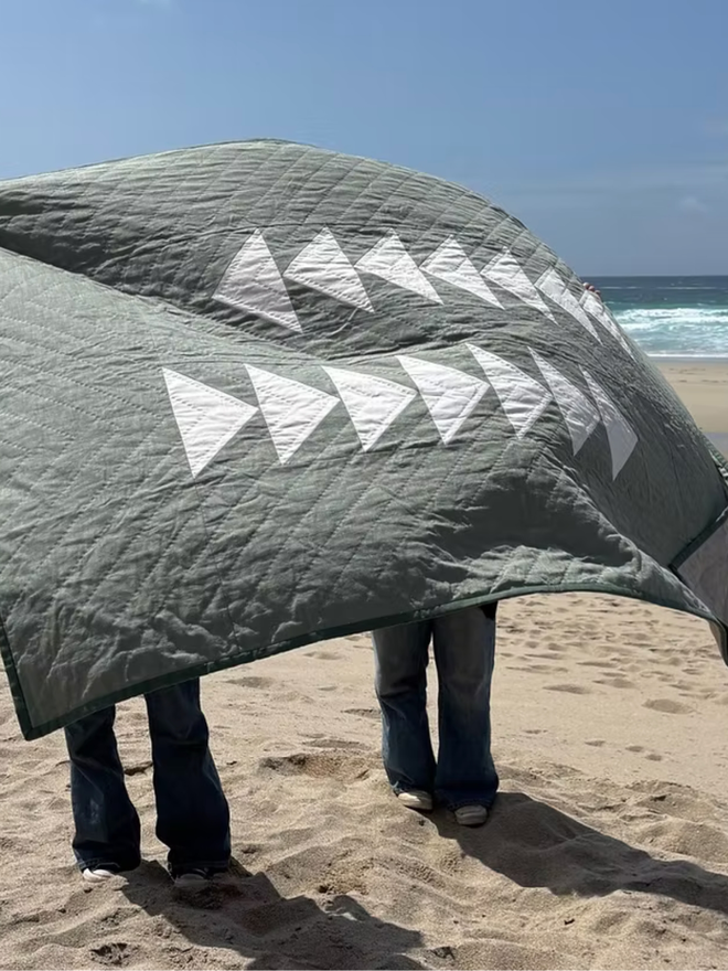 Flow Light Sage Green Linen Quilt. A green quilt with triangle design.