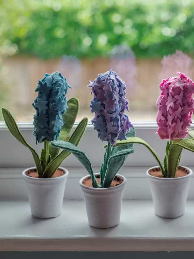 Little Egg teal, purple and pink Felt Faux Hyacinth Plant seen on a windowsill.