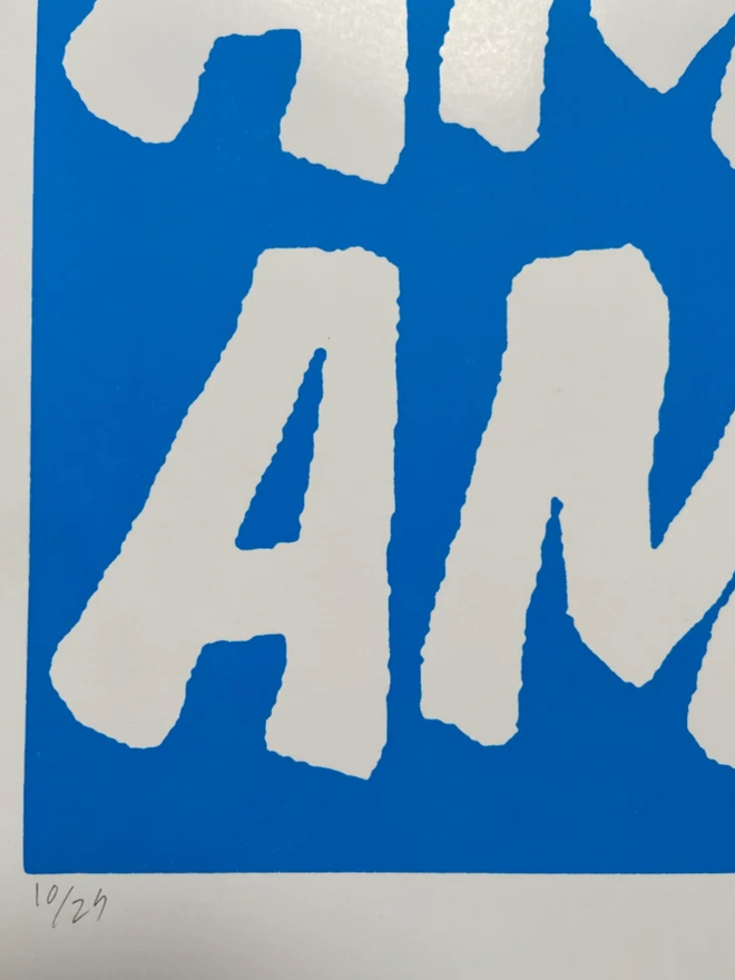 Fluoro Amazing Print. Close up of a print with a vibrant blue background, with AMAZING written five times.