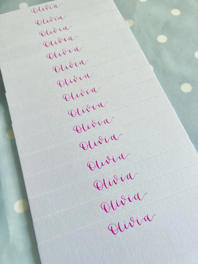 White notecards with Olivia written in pink calligraphy at the top of each card.