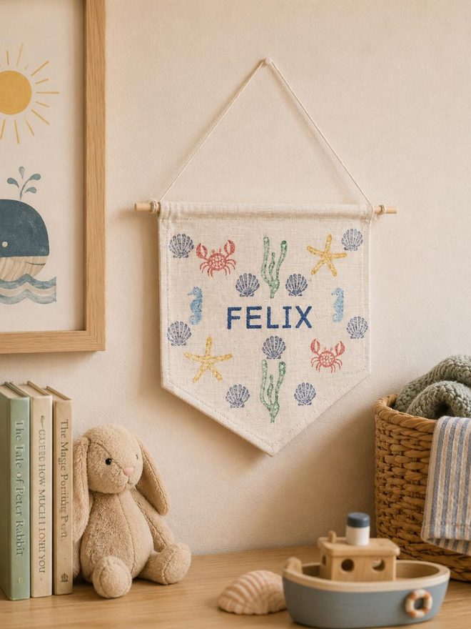 customised kids' bedroom cotton wall hanging. a banner with printed sea creatures hanging on a bedroom wall.