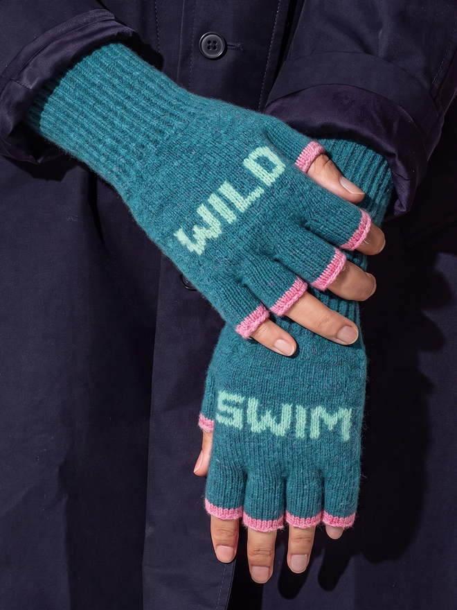 Lifestyle image of the Teal & Peppermint Wild Swim Mittens worn against a navy coat