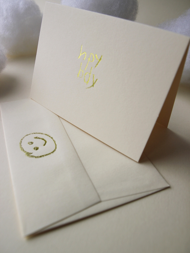 sandy coloured card with hpy bdy hand foiled in kids hand writing