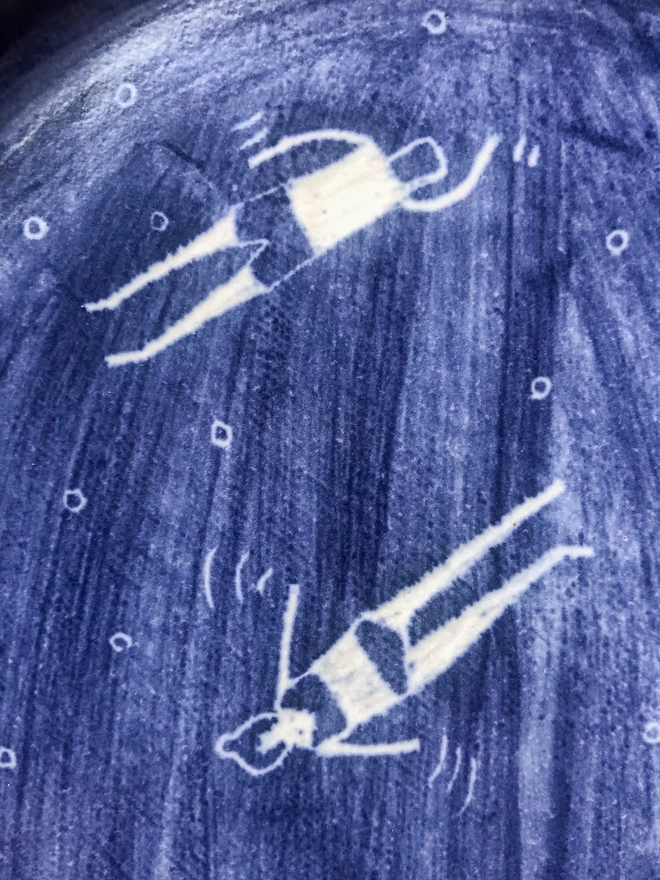 illustration detail of blue plate with white swimmers