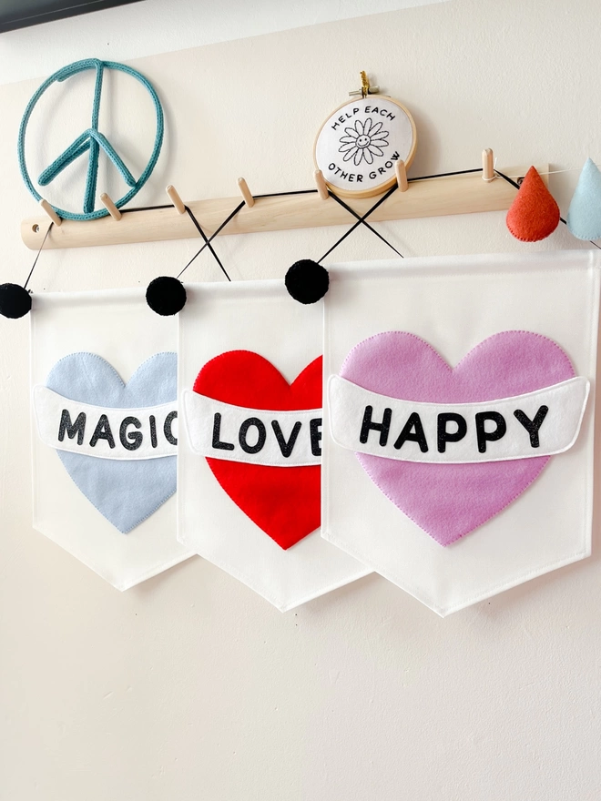Three heart banners saying magic loved happy