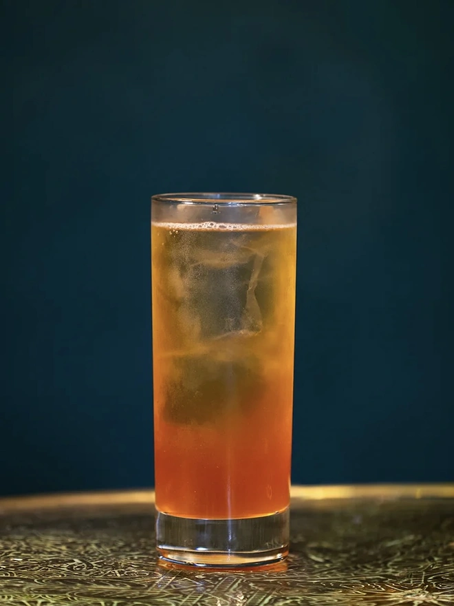 Paradiso Collins Cocktail In A Can, cocktail in a glass on a table. 