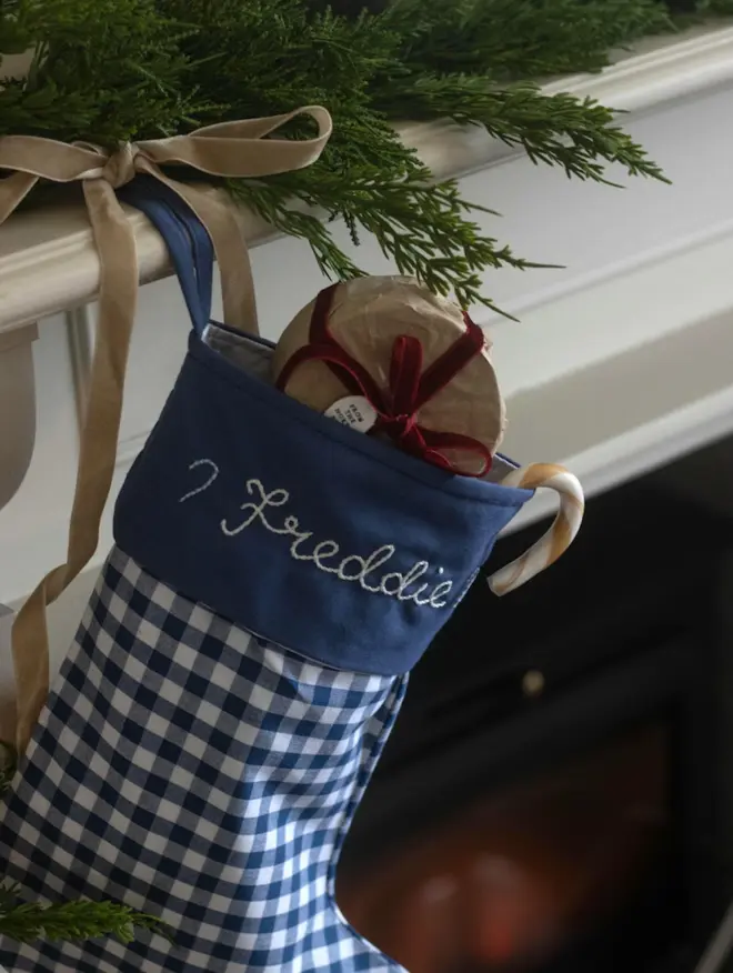 blue gingham stocking with personalised embroidered name hanging