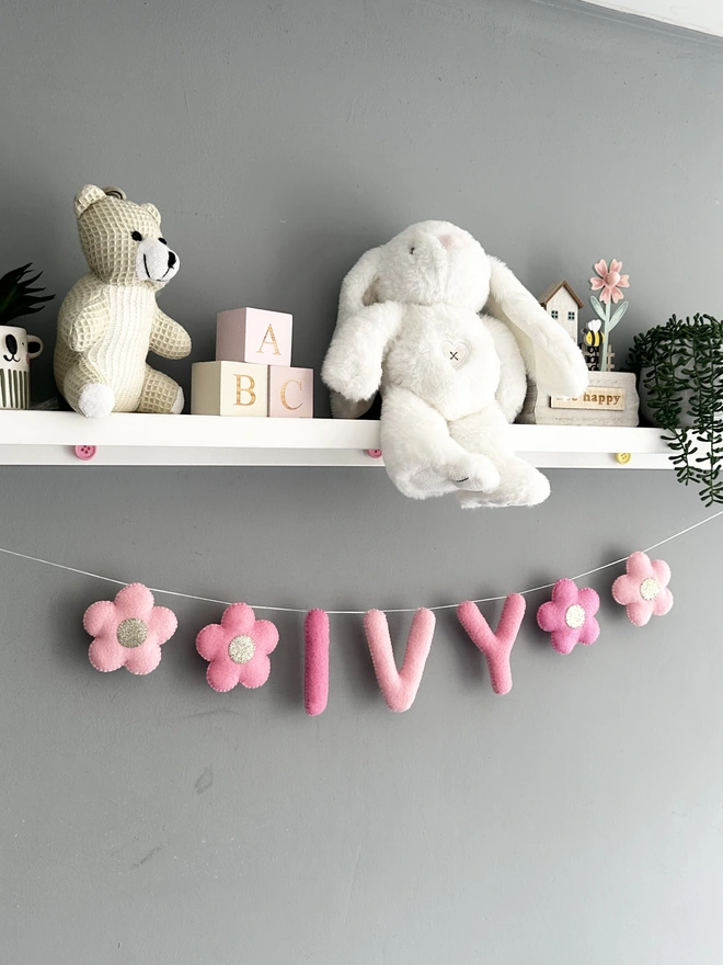 Personalised Name Icon Garland, a child’s name banner hanging from a. white shelf, nursery decoration, baby gift 