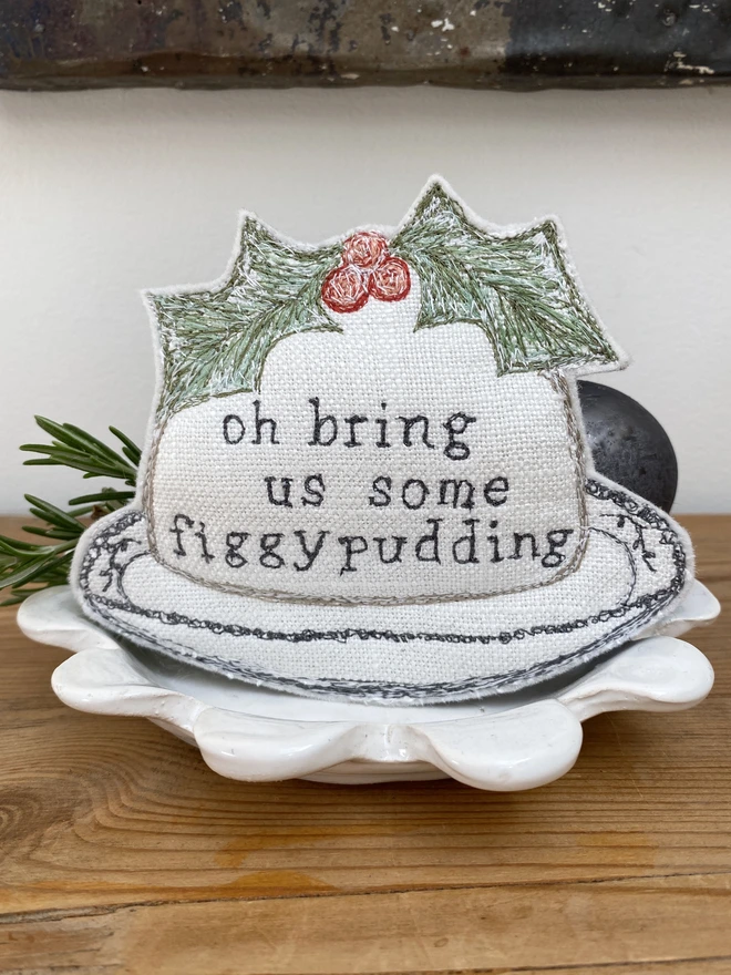 Figgy Pudding Embroidered Fabric Decoration on a plate