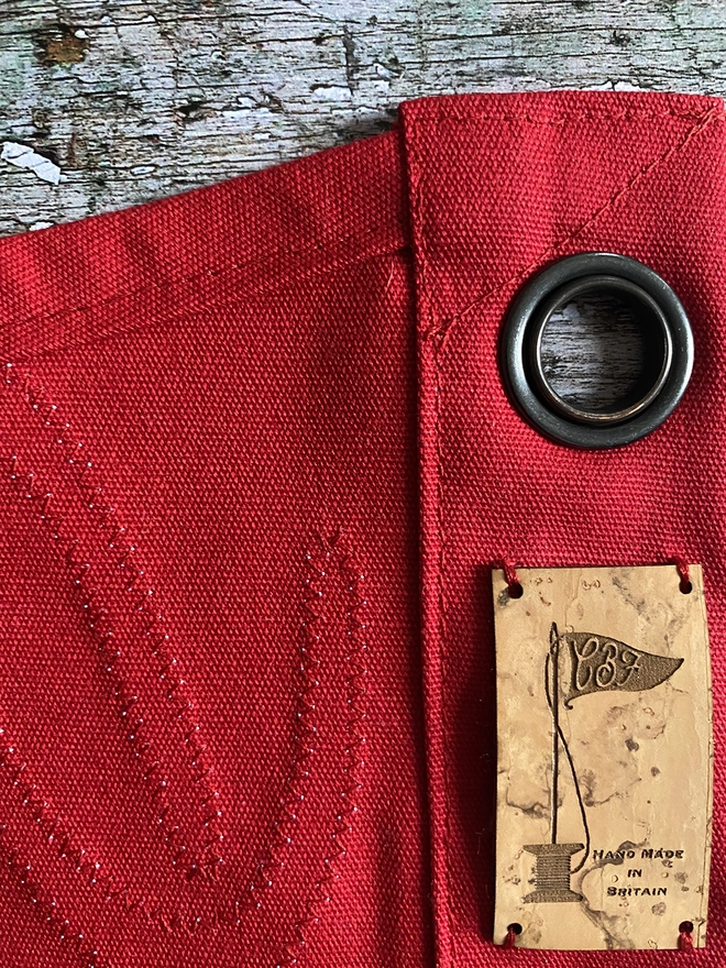 Showing a section of a red flag on the back to see the stitching and label