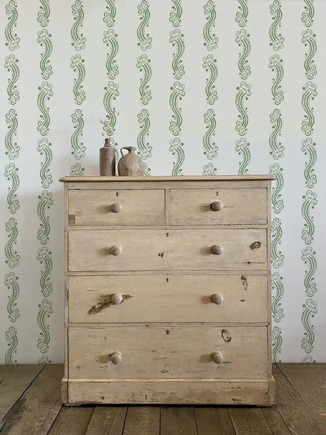 cedilla illustrated patterned wallpaper. a white background wallpaper with green squiggle patterns on a wall.