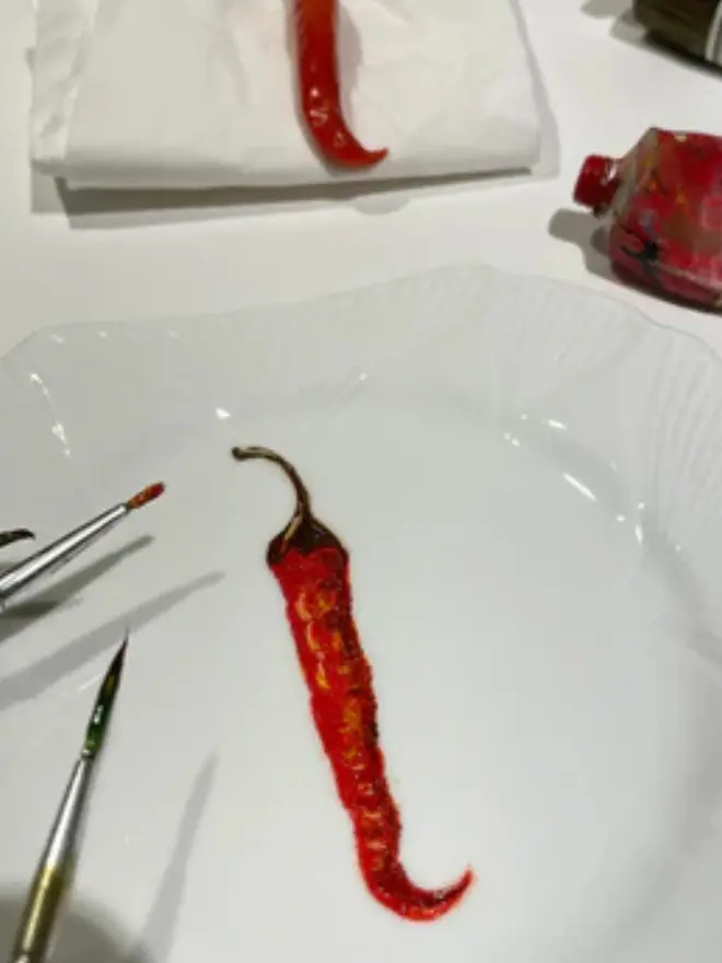 Oil Painted Chilli On Antique Tea Plate, in a studio next to a real chilli.