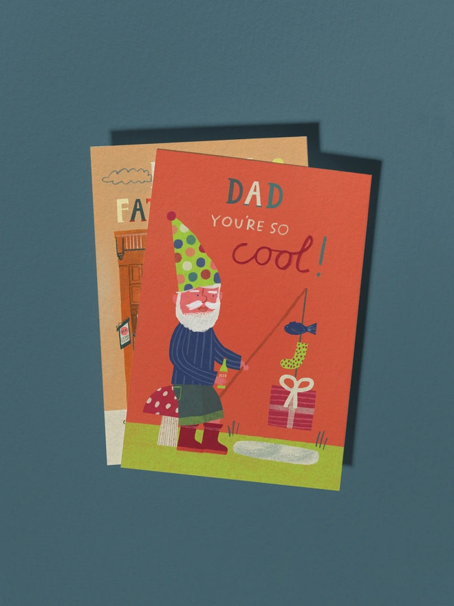 Colourful Gnome Dad sat on toad stool fishing for beer, presents and fish greeting card for birthday and fathers day