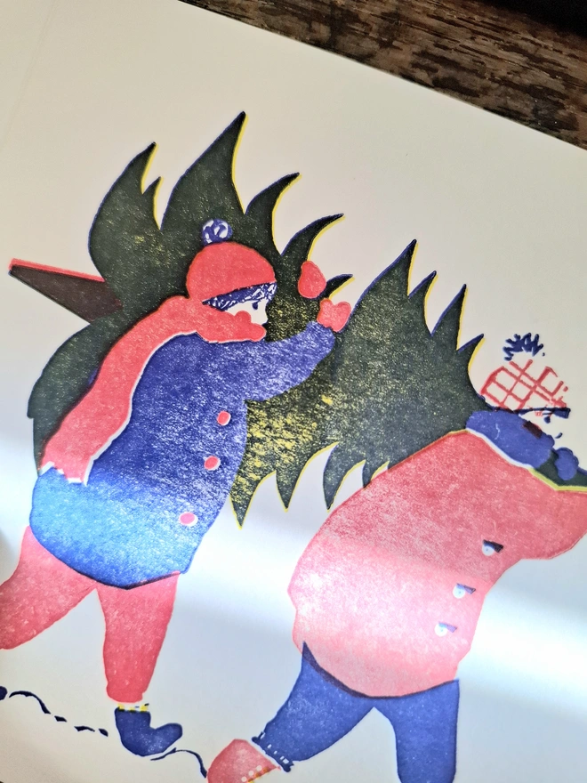 A close-up of an illustration on a greetings card, showing two figures carrying a Christmas tree on their shoulders, printed in red, blue and yellow.