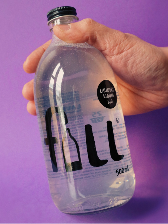 Laundry Liquid Bio. A bottle of laundry liquid being held.