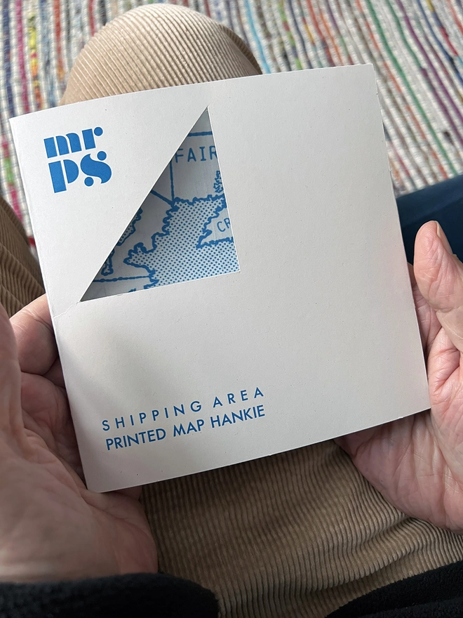 The packaging of a Mr.PS Shipping Forecast Area Handkerchief, made of recycled card with a triangle windo