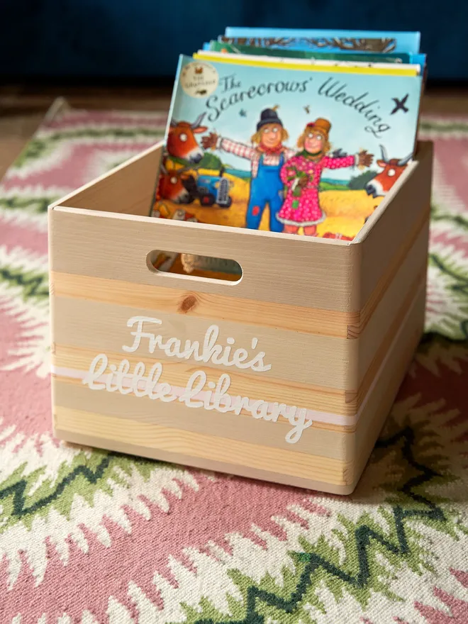 personalised kids' book storage box. a personalised wooden book box full of books.
