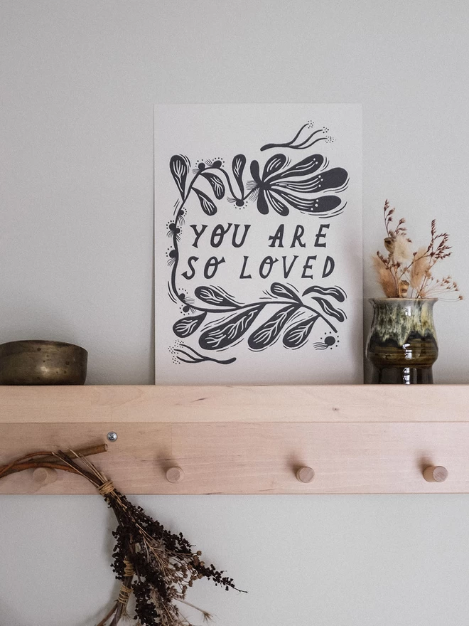 'You Are Loved' black and white art print with lino cut style botanical border