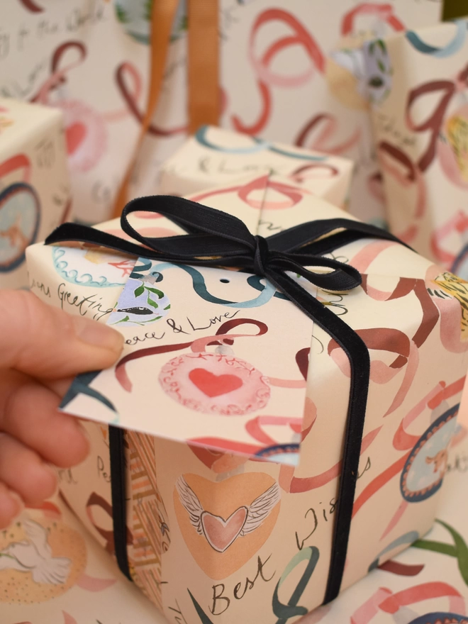 Liz Temperley's Christmas Baubles Wrapping Paper and peace & love gift tag seen on presents.