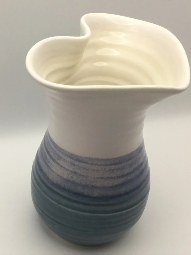 porcelain slate blue heart shaped vase. a blue vase with a heart shape opening and round base.