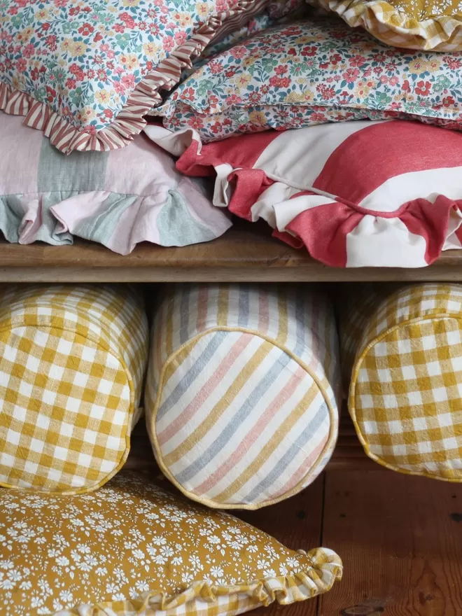 Linen Bolster Cushion 'Seaside Stripe' close up of the cushion displayed with other cushions 