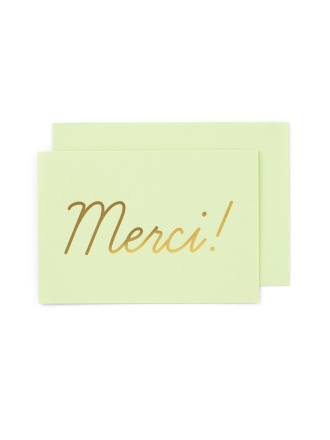 An elegant thank you card in mint green greeting card that says 'Merci!', wth an envelope that has a gold seal