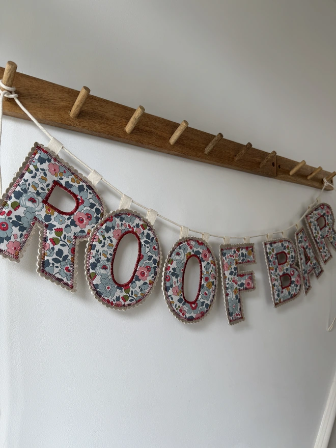 Fabric Letter Garland. Garland spelling ROOF BAR  in red florals