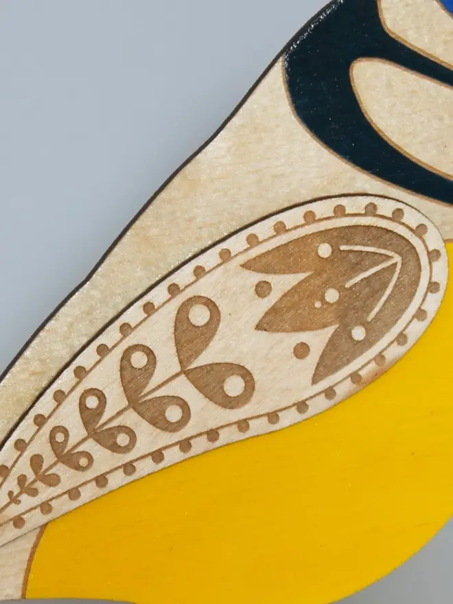 Standing Wooden Blue Tit, yellow wooden bird decoration standing on a platform. 