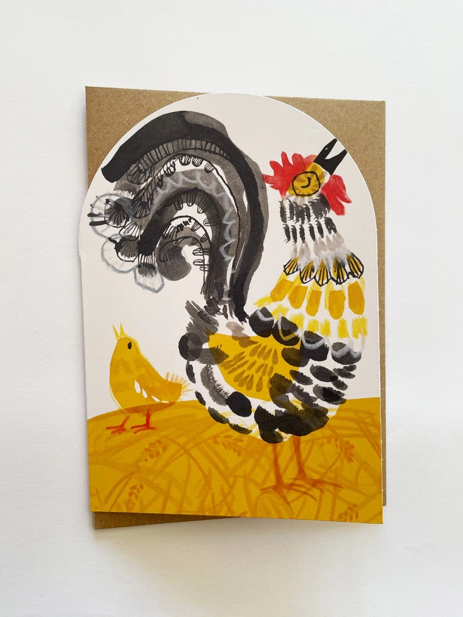 Esther Kent illustrated greeting card showing black, yellow and red stylised cockerel on an arch-shaped card
