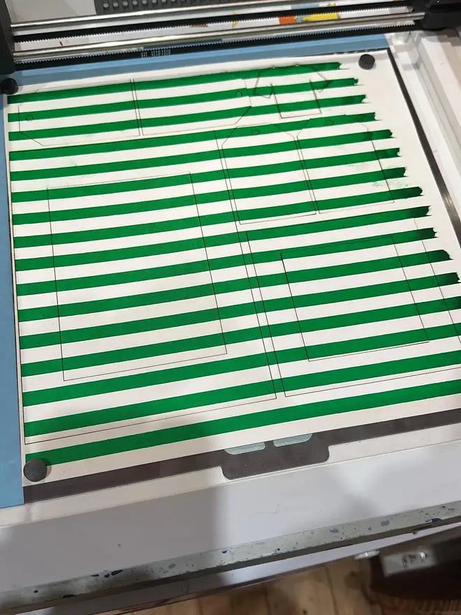 striped a4 / a5 screen print photo mount. green variant shown on screen printer during making process.