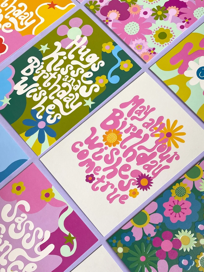 A flatlay on lilac of colourful 1970’s inspired greeting cards from the Raspberry Blossom ‘Big Love’ collection, the cards have bold patterns and chunky 70’s inspired hand lettering all in a beautifully curated colour palette 