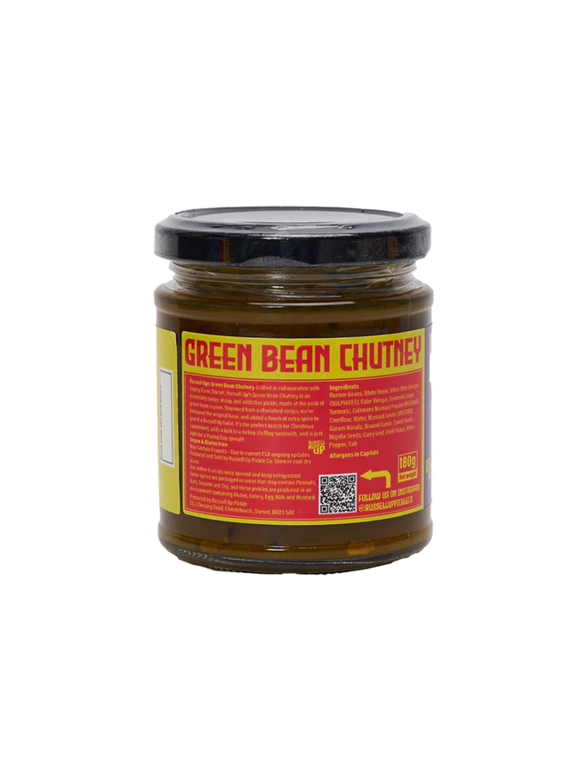 green bean chutney. a jar of green bean chutney photographed against a white background, photographed from the back to show ingredients listed on the label.