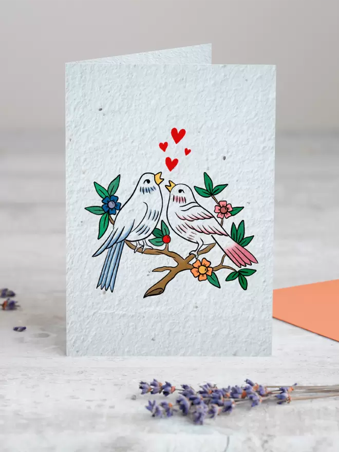 Seeded Paper Greeting Card featuring an illustration of two birds sitting on a branch with a sprig of Lavender placed in the foreground of the image
