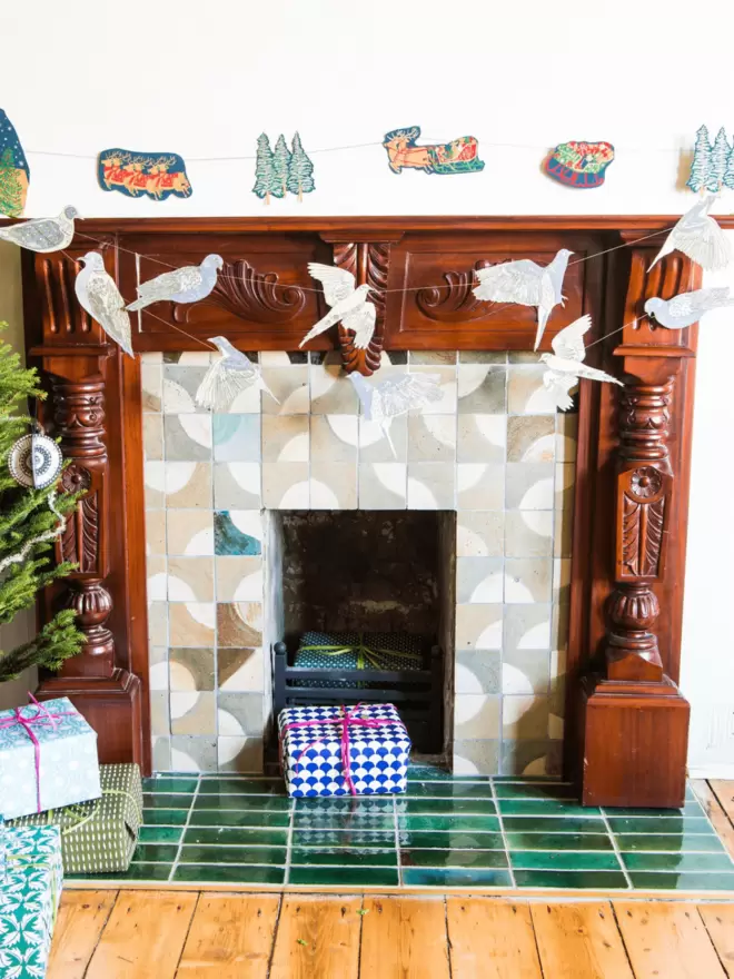 Full view of wooden fireplace with turtle dove and skyline garland decorating 