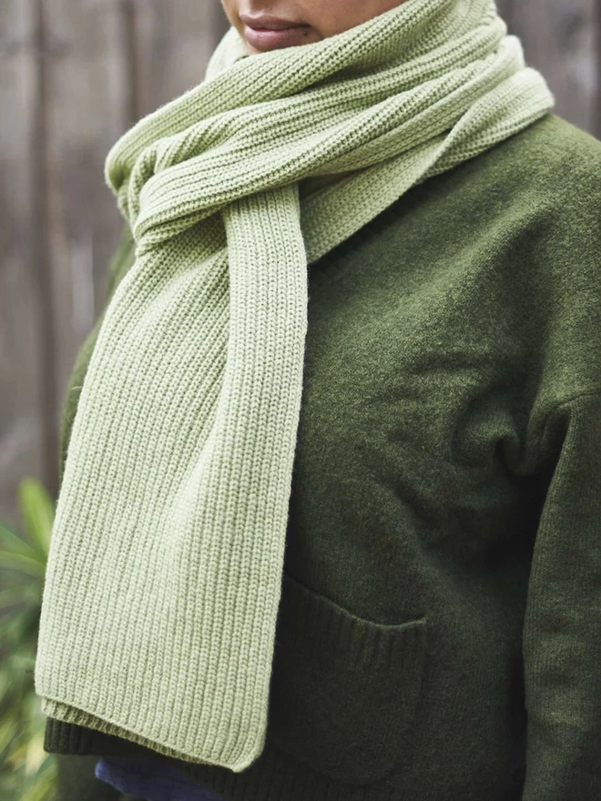 Lambswool Ribbed Scarf, a woman wearing a colourful ribbed scarf outdoors. 