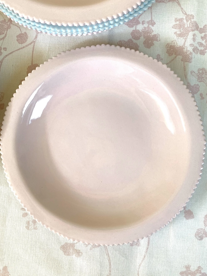 top view of pale pink pasta bowl with scalloped edge