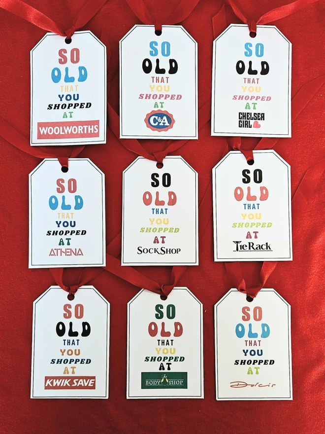 A photograph of six gift tags that say so old you shopped at Woolworths, C&A, Chelsea Girl, Athena, Sock Shop, Tie Rack, Kwik Save, The Body Shop and Dolcis 