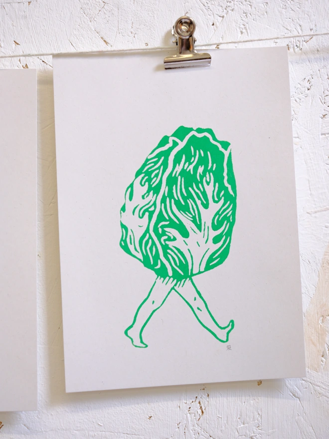 a close up of the print which is a graphic lettuce with legs