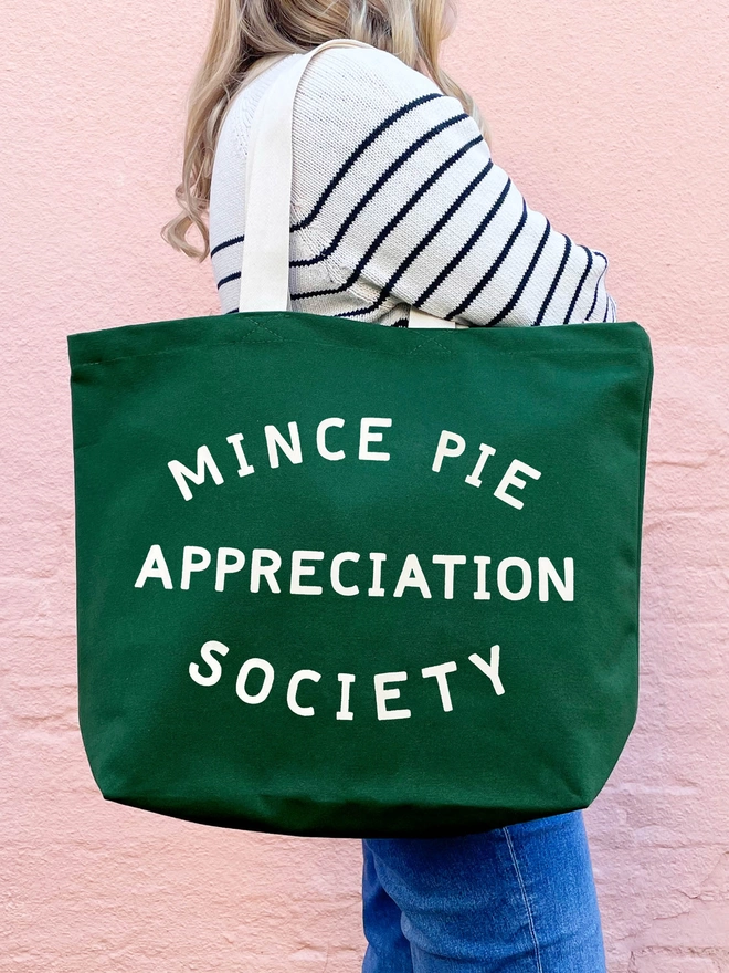 Model carrying a Green canvas Mince Pie Appreciation Society tote bag