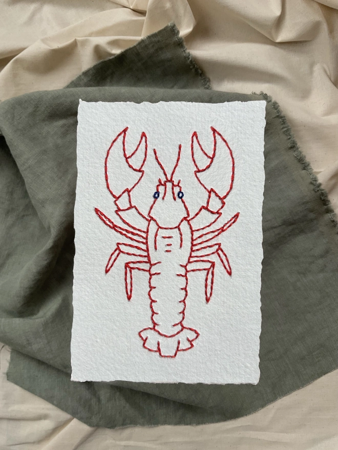 Lobster hand embroidery in red cotton on white khadi paper