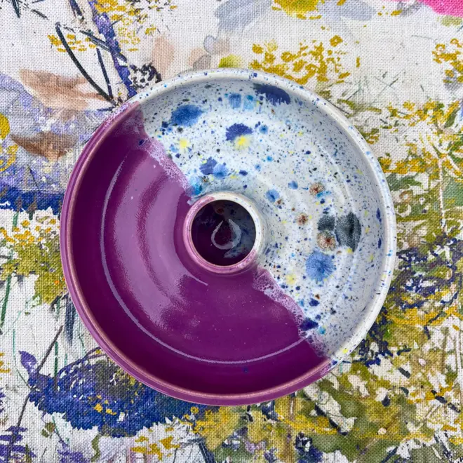 Shoreline Candle Stick Holder, a colourful candle stick holder sitting on a painted surface. 