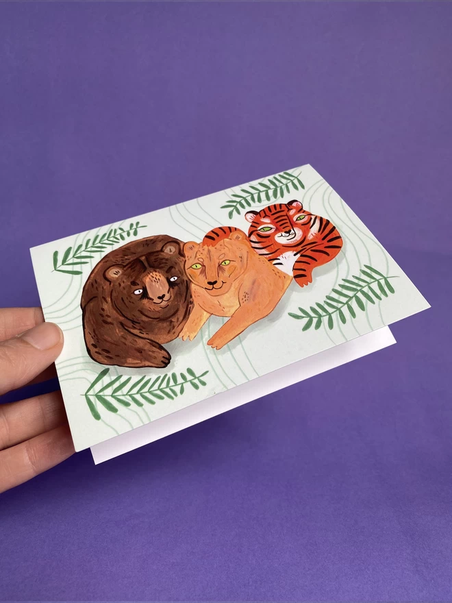 A trio of wild animal pals, the BLT,  A Bear, Lion and Tiger illustrated on a landscape A6 Greeting Card 