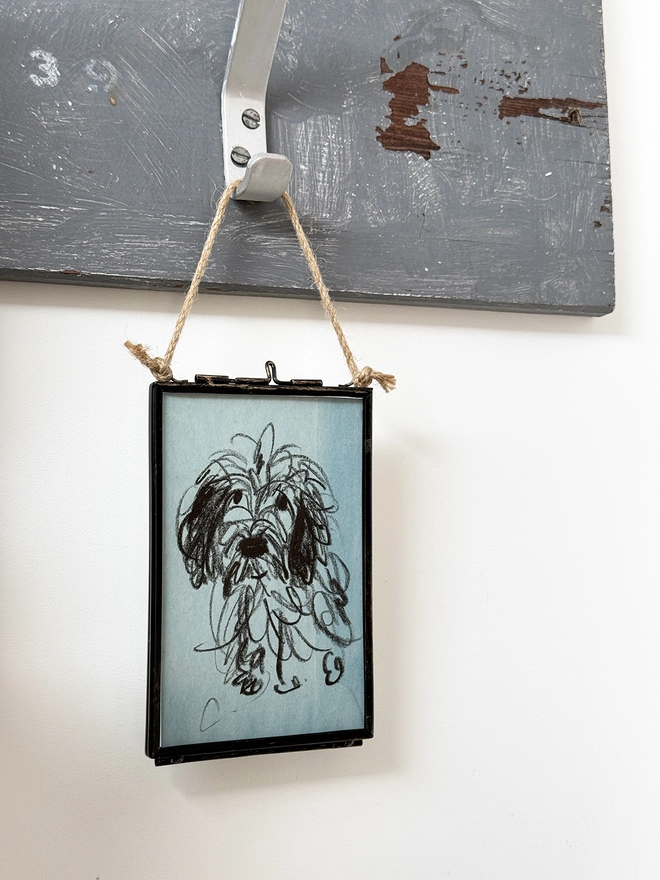 sketchy portrait of dog on blue paper in metal frame