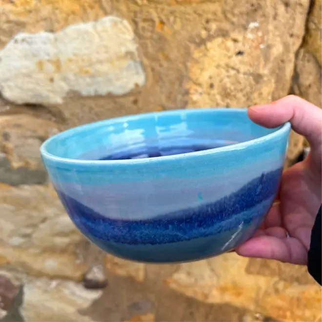 Landscape Ramen Bowl, a colourful ramen bowl held in front of a brick backdrop. 
