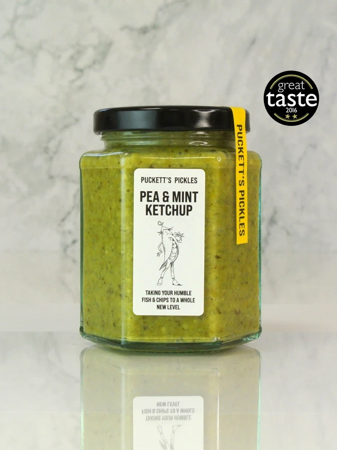 pea and mint ketchup. a jar of pea and mint ketchup photographed on a marble background.