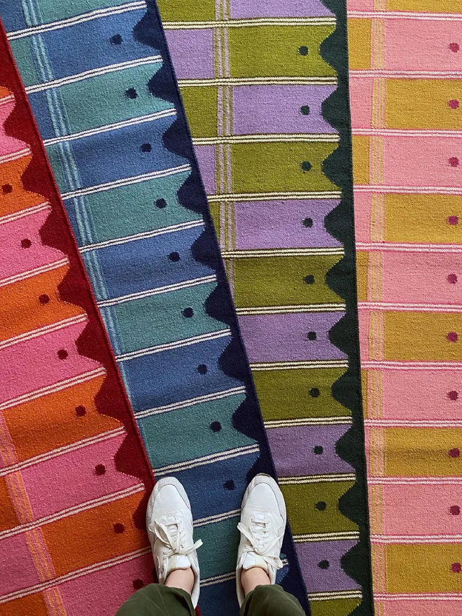 Colourful handwoven Ladder Flatweave Runner Rug in multiple colourways, styled on the floor with someone standing on it.