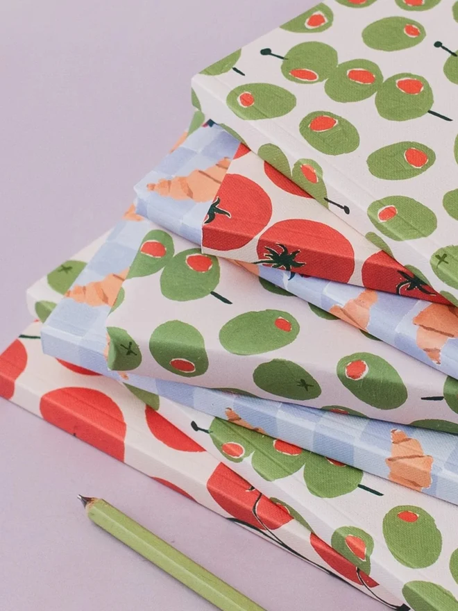 Olives and Tomatoes Notebooks stacked with a pencil